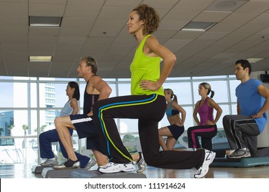 People Exercising On Step In Aerobics Class