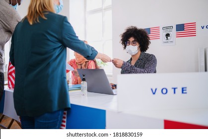 People with face mask voting in polling place, usa elections and coronavirus.