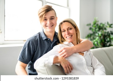 A people and family happy teen boy with mother on sofa at home - Shutterstock ID 1295381839