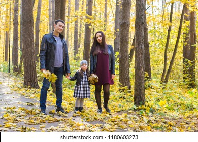 People, family and leisure concept - happy family with daughter walking in autumn park - Shutterstock ID 1180603273