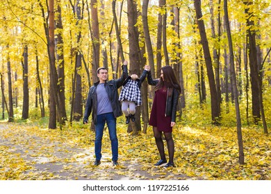 People, family and leisure concept - mixed race father and mother have fun in autumn park with their daughter - Shutterstock ID 1197225166