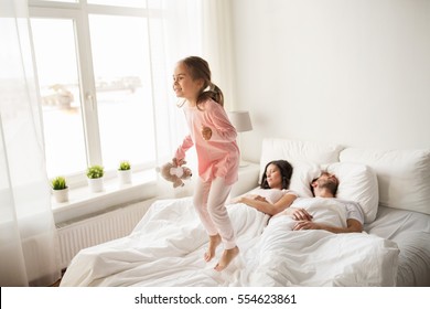 People, Family And Morning Concept - Happy Child With Toy And Parents In Bed At Home