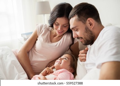 People, Family And Morning Concept - Happy Child With Parents In Bed At Home