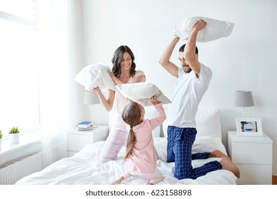 People, Family And Morning Concept - Happy Child With Parents Having Pillow Fight In Bed At Home