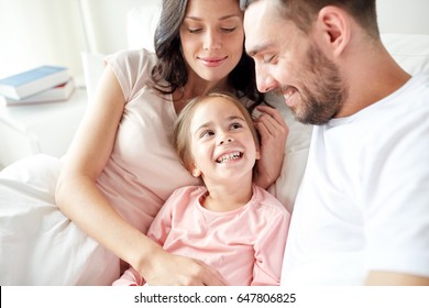 People, Family And Morning Concept - Happy Child With Parents In Bed At Home