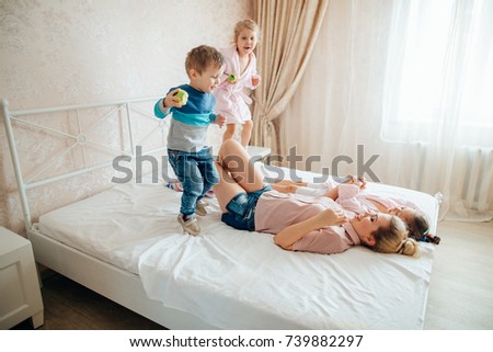 Similar – Relaxed mother and sons playing over the bed