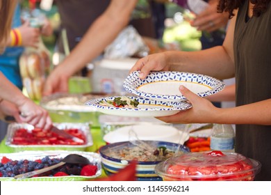 People Filling Plates At A Summer Cookout