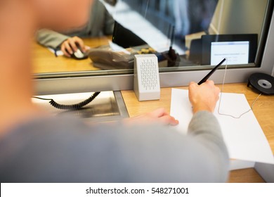 people and finance concept - customer with pen and paper writing application at bank office