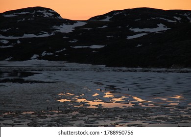 People Fishing Under The Midnight Sun. In The Cape Dorset Bay