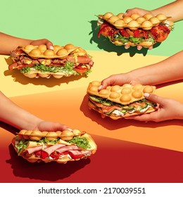 People with food. Hand holding bubble waffle sandwiches with colourful background. Fast food, take away. Snack. Party. Concept