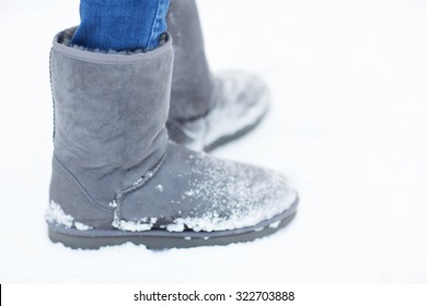 People, Footwear, Winter And Clothing Concept - Close Up Of Woman Legs Wearing Warm Boots On Snow