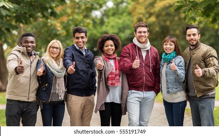 people, friendship, communication and international concept - group of happy friends showing thumbs up at autumn park - Powered by Shutterstock