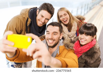 People, Friendship, Technology And Leisure Concept - Happy Friends Taking Selfie With Smartphone On Skating Rink