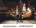 People in front of model of Vasa, viking ship. The ship itself in the background