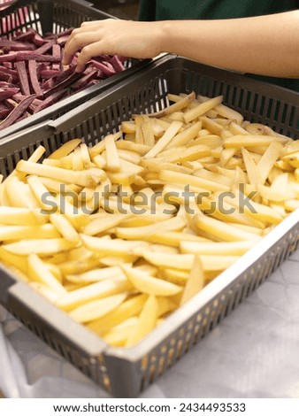People are frying frenchfries. Purple Frenchfries from purple potatoes