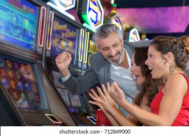 People Gambling In A Casino Playing Slot Machine