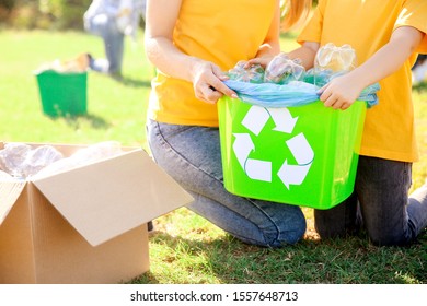 People gathering garbage outdoors. Concept of recycling - Shutterstock ID 1557648713