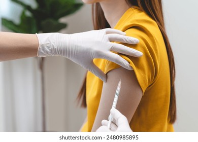 People getting a vaccination to prevent pandemic concept. Woman in medical face mask receiving a dose of immunization coronavirus vaccine from a nurse at the medical center hospital - Powered by Shutterstock