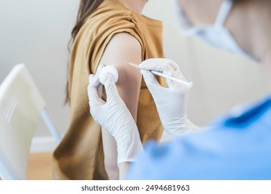 People getting a vaccination to prevent pandemic concept. Woman in medical face mask  receiving a dose of immunization coronavirus vaccine from a nurse at the medical center hospital - Powered by Shutterstock