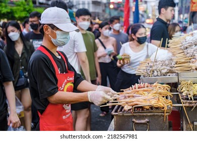 People Grilled Squid On A Cast Iron Grill Over A Charcoal Grill, Calamari Fish Bbq On The Market, China Town Bangkok Thailand, China Town Bangkok July 2022