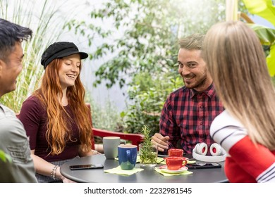 People group drinking latte at coffee bar garden - Happy friends talking and having fun together at hostel dehors - Lifestyle concept with happy guys and girls at open-air cafe - Warm vivid filter - Shutterstock ID 2232981545