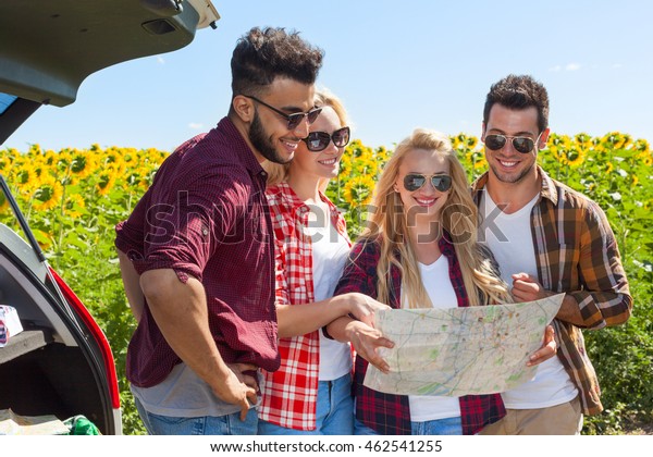 People\
group looking road map standing sunflowers field outdoor, two\
couple near car summer day friends holiday\
trip