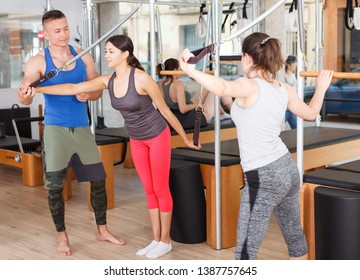 people in the gym doing exercises with modern fitness equipment