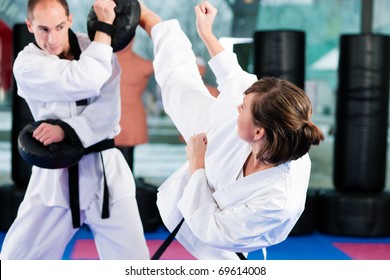 People In A Gym In Martial Arts Training Exercising Taekwondo, Both Have A Black Belt