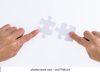 People hand connect two couple puzzle pieces. - Shutterstock ID 1657708114