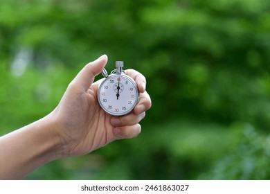 People hand holding stopwatch outdoors - Powered by Shutterstock