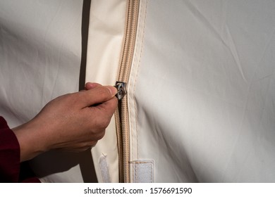 People Hand Is Sliding Zip Part Of Camping Tent To Close/open The Door. Camping Activity Close-up Action Photo.