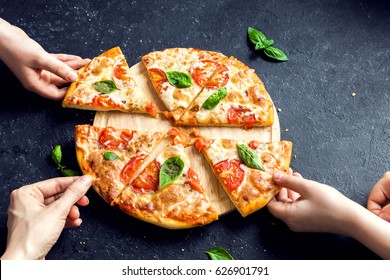 People Hands Taking Slices Of Pizza Margherita. Pizza Margarita and  Hands close up over black background. - Powered by Shutterstock