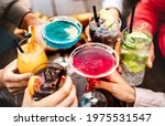 People hands toasting multicolored fancy drinks - Young friends having fun together drinking cocktails at happy hour - Social gathering party time concept on warm vivid filter - Shallow depth of field