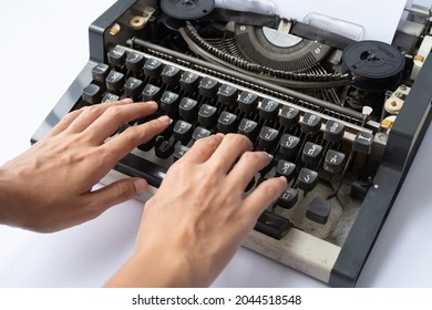 People hands typing an old Thai traditional typewriter. Classic vintage antique manual typing machine isolated on white background. 19th century item. Lifestyle