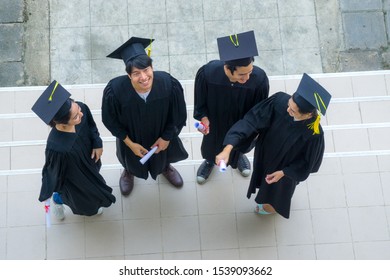 People Are Happy In Graduation Gowns And Cap Stand In The Line (top Aerial View).