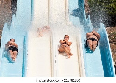 People having fun, sliding at water park.