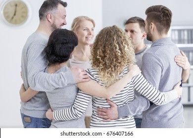 People Having Group Hug During Therapy In Rehab