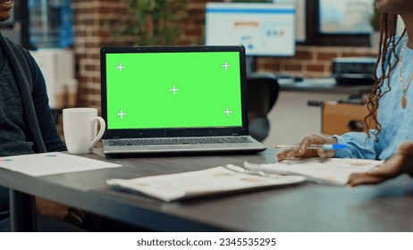 People having laptop with greenscreen on desk, talking about development in briefing meeting. Corporate workers looking at blank mockup chroma key isolated display, startup office. - Powered by Shutterstock