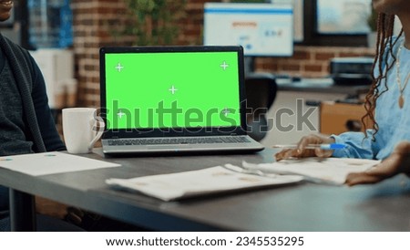 People having laptop with greenscreen on desk, talking about development in briefing meeting. Corporate workers looking at blank mockup chroma key isolated display, startup office.