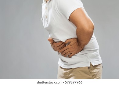 people, healthcare and health problem concept - close up of man suffering from stomach ache over gray background - Shutterstock ID 579397966