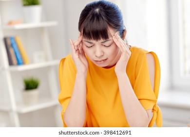 People, Healthcare, Stress And Problem Concept - Unhappy Asian Young Woman Suffering From Headache At Home