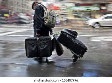 People With Heavy Luggage On A City Street