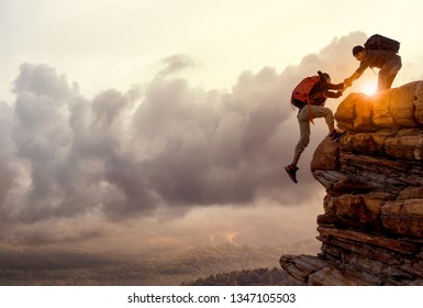 People helping each other hike up a mountain at sunrise. Giving a helping hand, and active fit lifestyle concept.Asia couple hiking help each other. - Shutterstock ID 1347105503