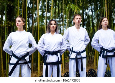 People High Kicks During Training Of Taekwondo Outdoors Bamboo Background