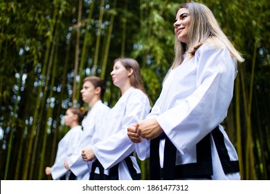 People High Kicks During Training Of Taekwondo Outdoors Bamboo Background