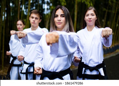 People High Kicks During Training Of Taekwondo Outdoors Bamboo Background