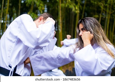 People High Kicks During Training Of Taekwondo Outdoors Bamboo Background