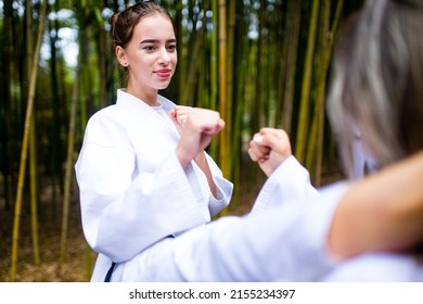 People High Kicks During Training Of Taekwondo Outdoors Bamboo Background