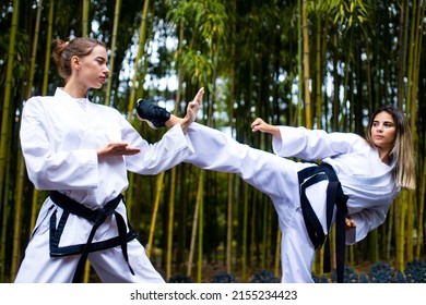 People High Kicks During Training Of Taekwondo Outdoors Bamboo Background