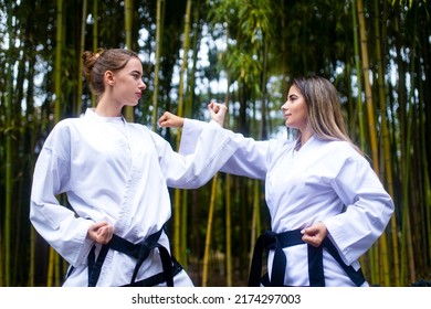 People High Kicks During Training Of Taekwondo Outdoors Bamboo Background